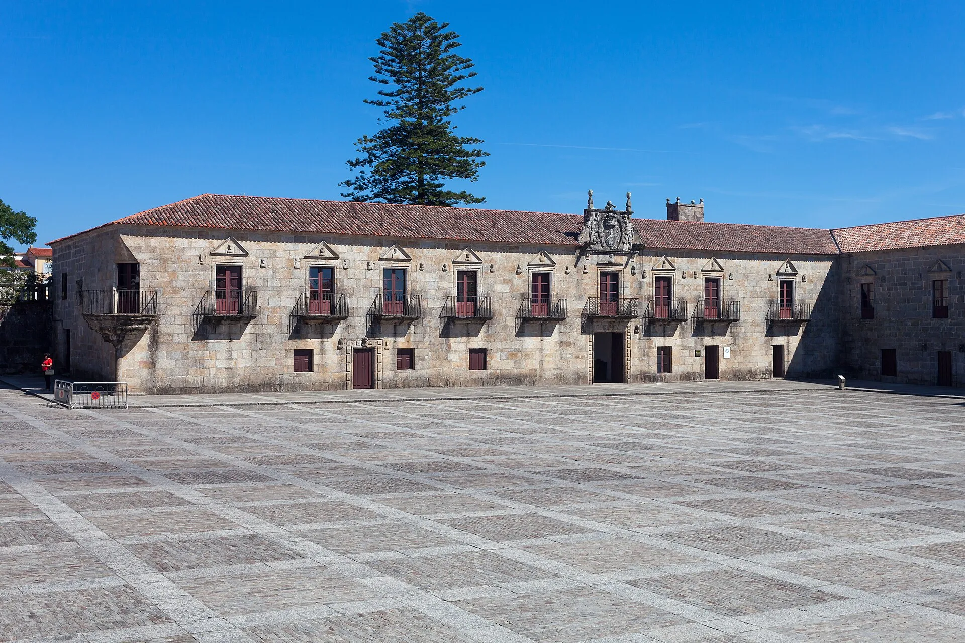 Fachada de piedra del Pazo de Fefiñáns, con balcones de hierro, frente a la gran plaza enlosada de Cambados.